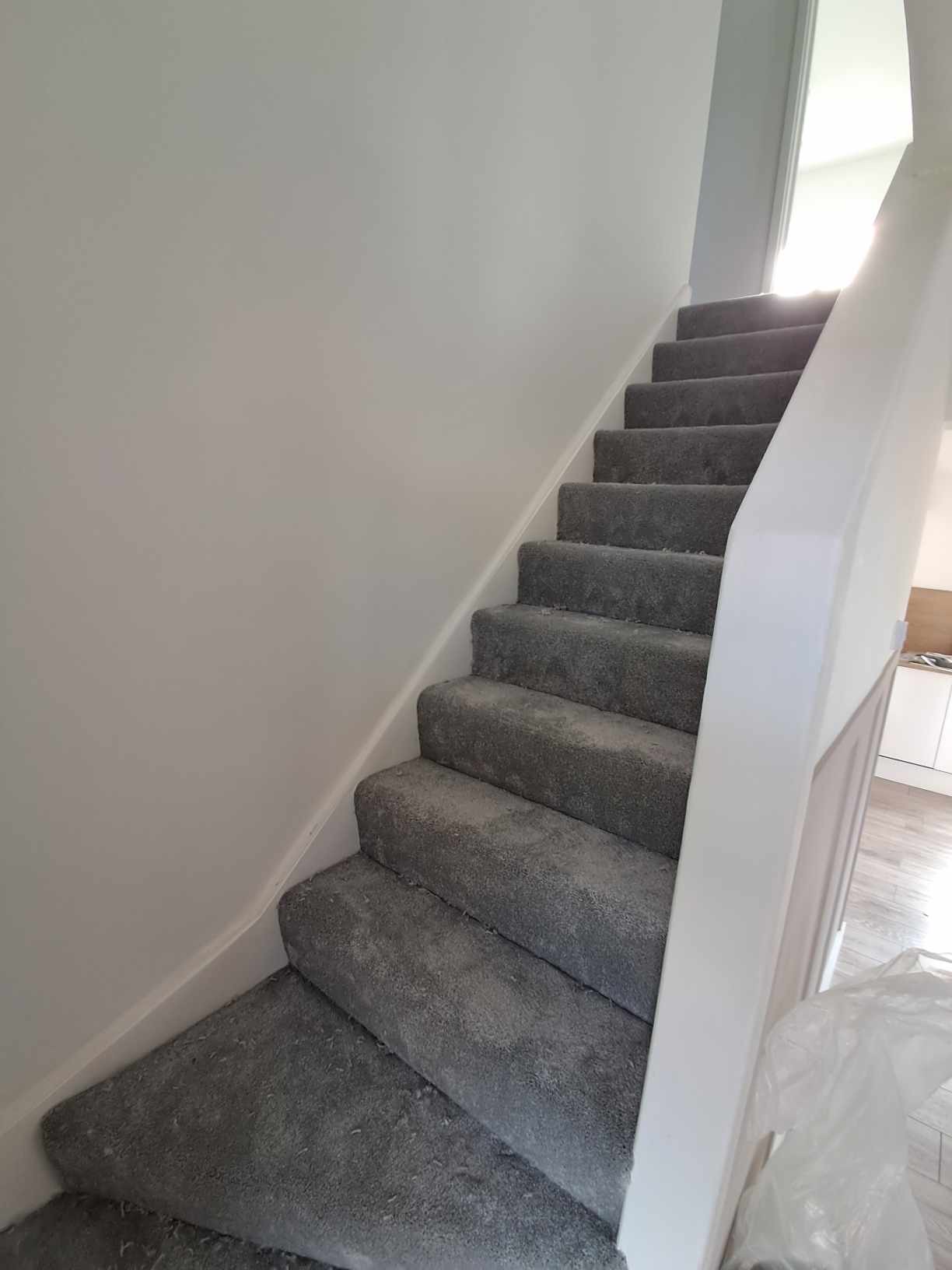 Grey carpet fitted on a winding staircase