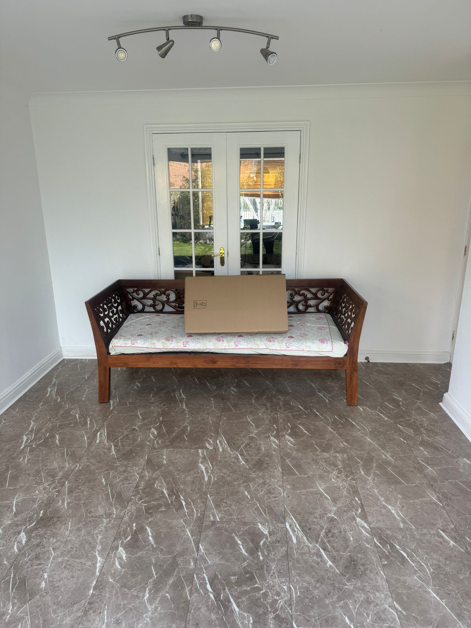 Patterned flooring in a finished room with a wooden bench